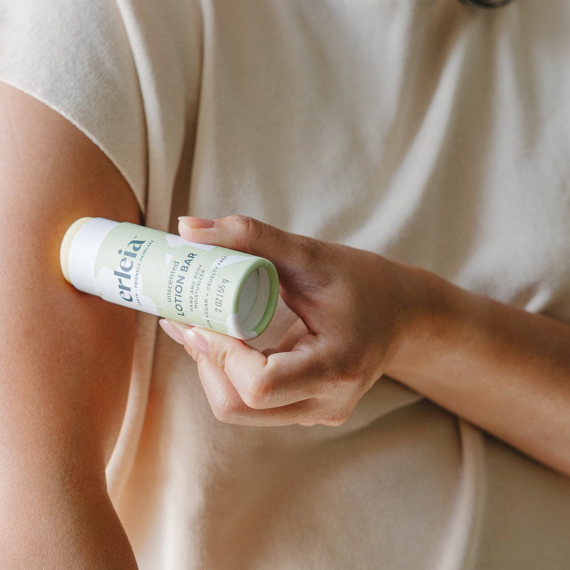 An Erleia unscented lotion bar being applied to an East Asian woman's arm