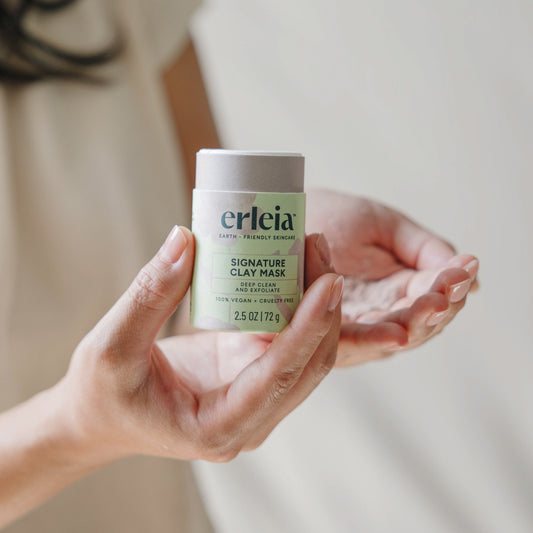 East Asian hands holding an open Erleia Signature Clay Mask