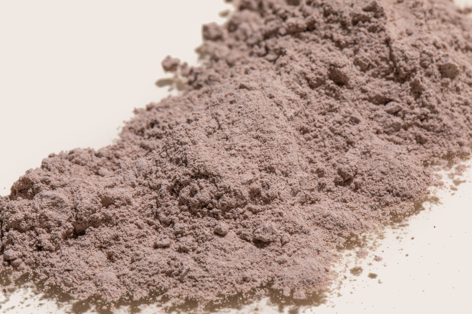 A pile of finely milled Erleia Signature Clay Mask powder, ready to be mixed for use in deep cleansing and exfoliation.