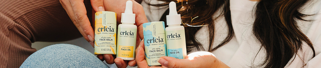 Hands holding Erleia face balms and face oils in warm natural light