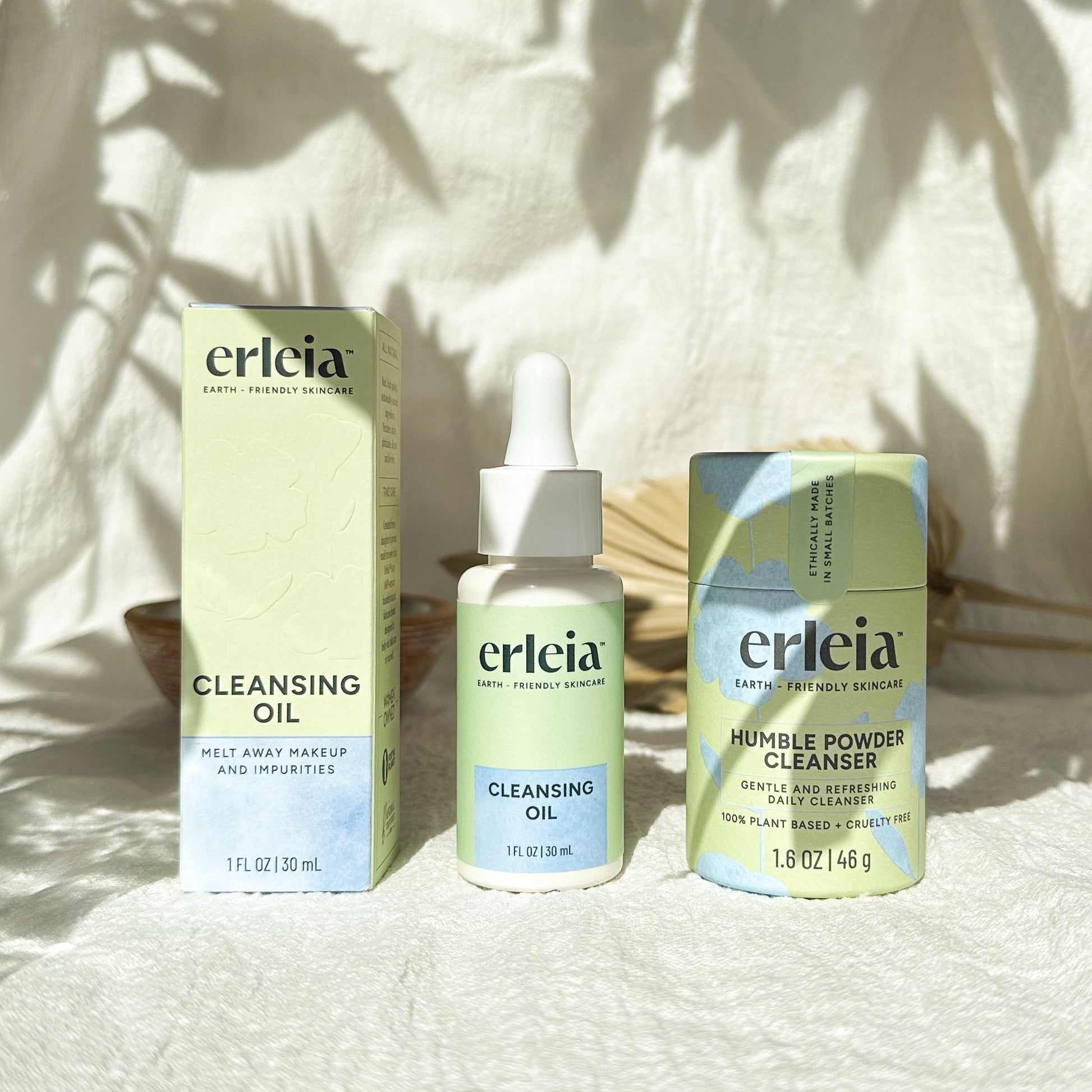 Erleia Double Cleanse Products - Cleansing Oil and Humble Powder Cleanser - on a neutral background with harsh shadows