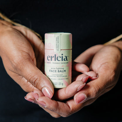 Black hands holding an Erleia acne fighting Face Balm