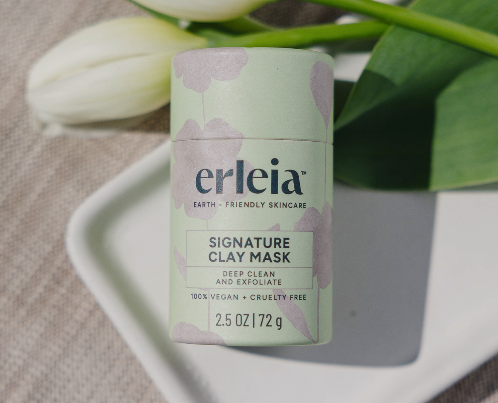 Erleia’s signature clay mask is displayed in eco-friendly packaging, with natural elements in the background, emphasizing its deep cleaning and exfoliating benefits along with its vegan and cruelty-free formulation.